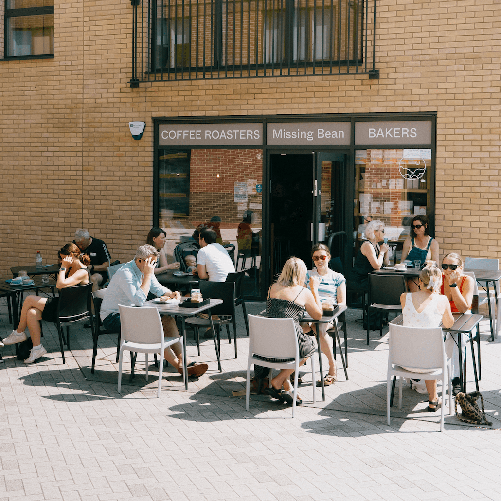 People sit enjoying coffee at the outside eating area of Missing Bean independent coffee shop in Botley, Oxford.