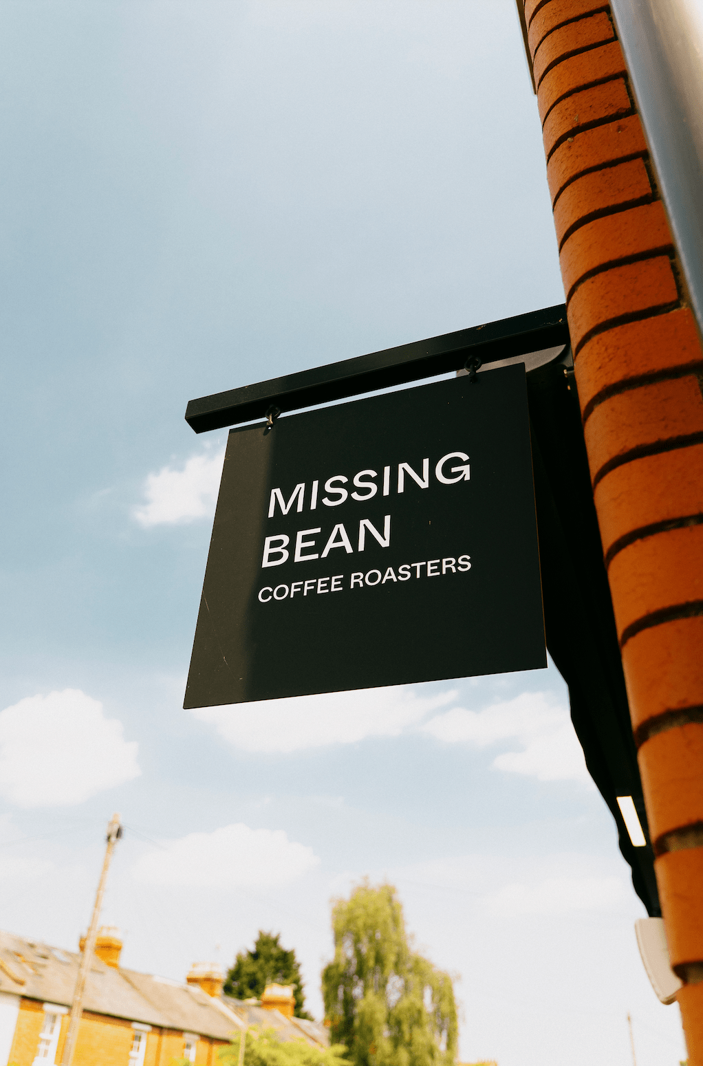 A black wall sign with white writing for the Missing bean coffee roasters.